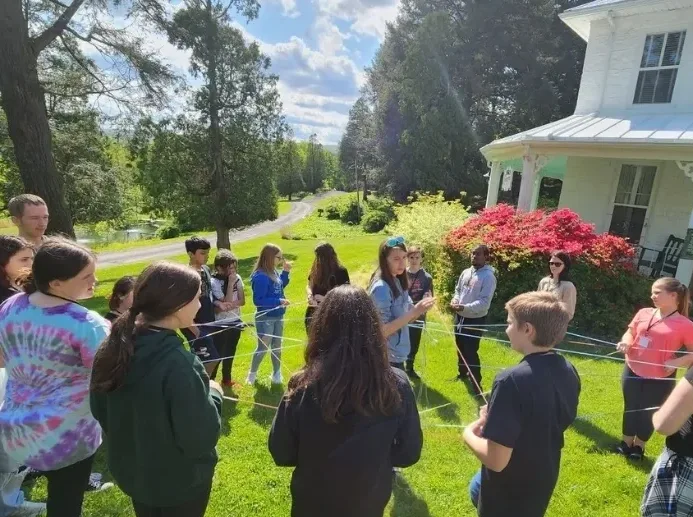 A group of people standing in the grass.