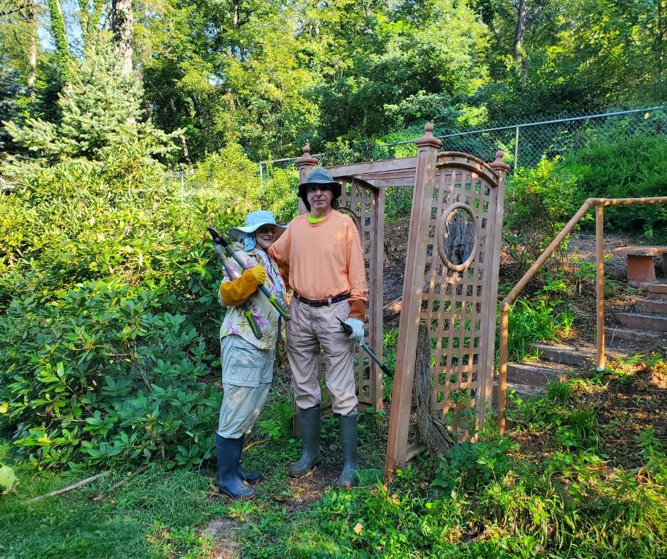 A man and woman standing next to a gate.