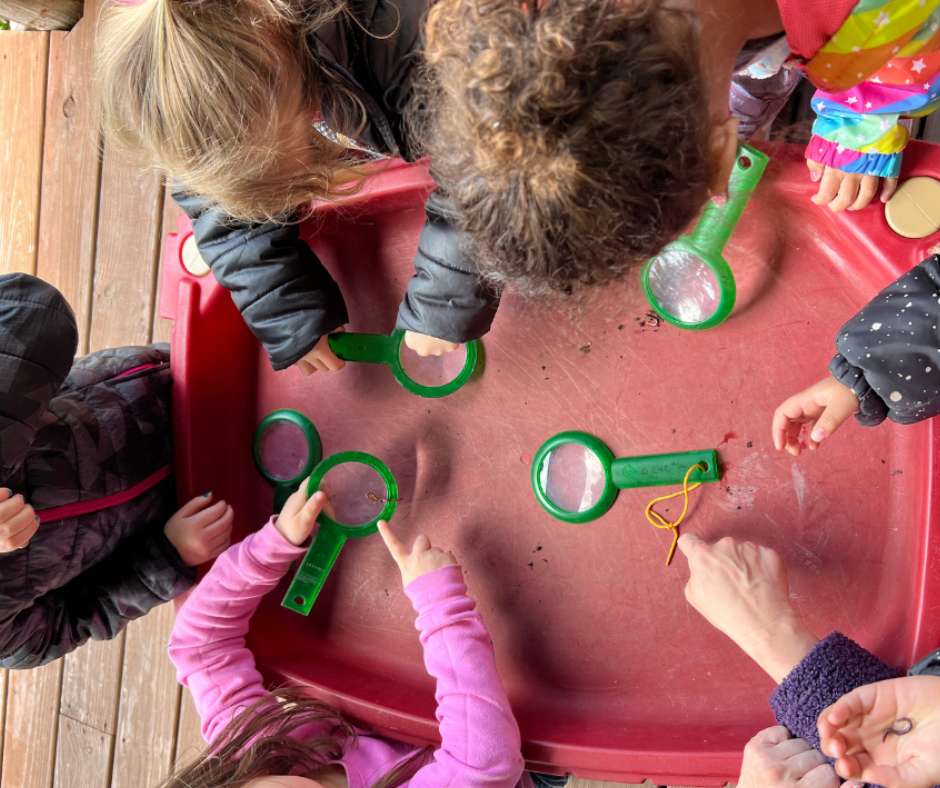 A group of children playing with magnifying glasses.