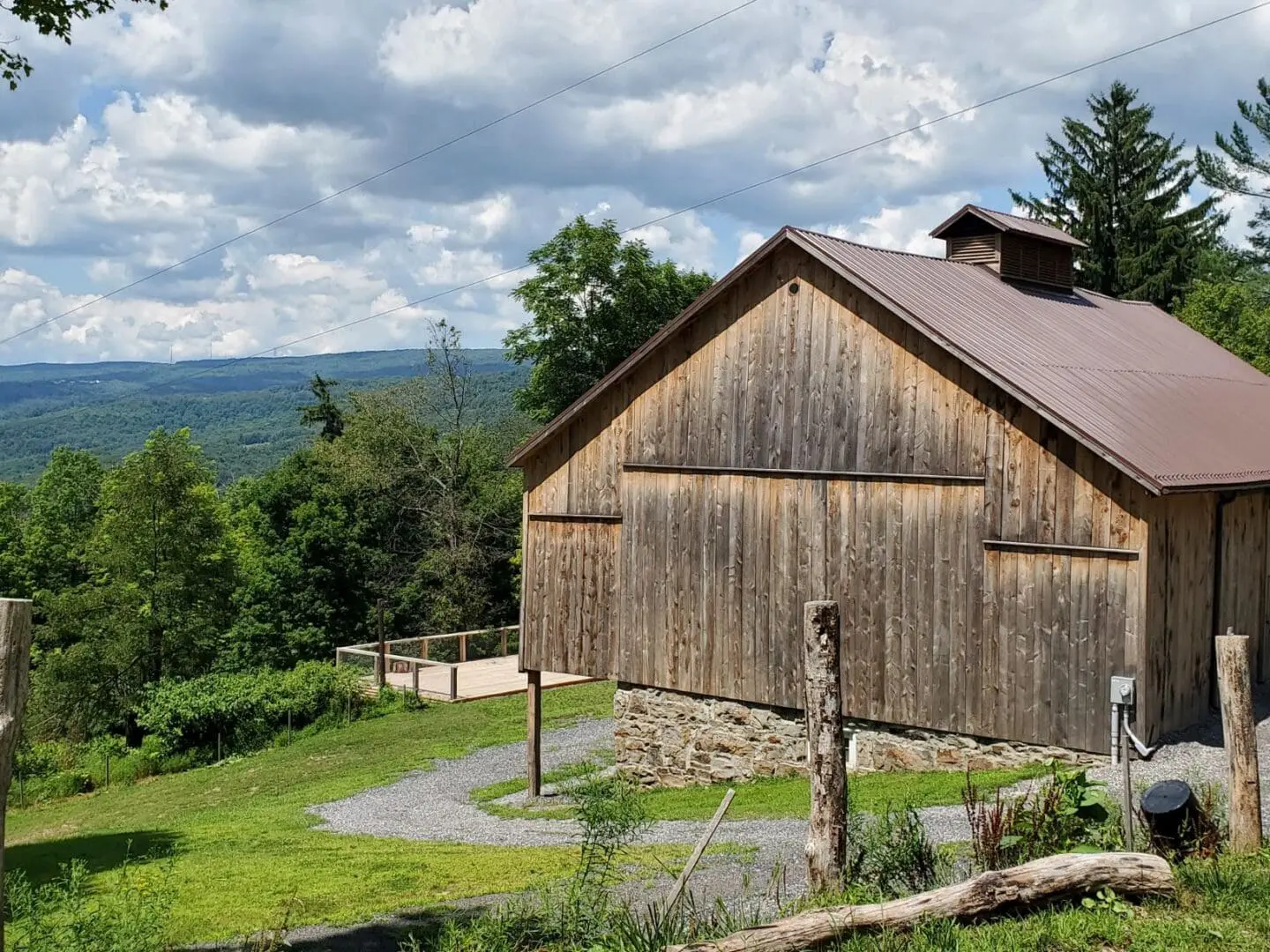 A barn with a fence and some trees in the background