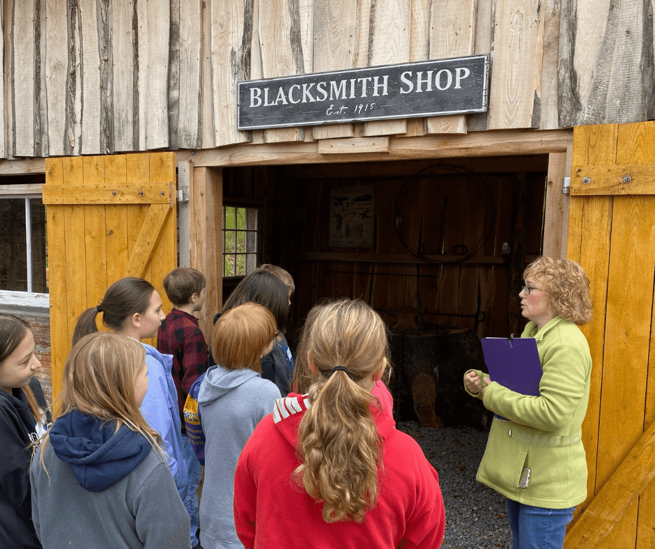 Students tour a historic blacksmith shop.