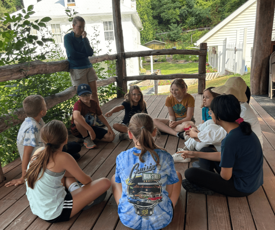 Group of kids sitting on a porch.