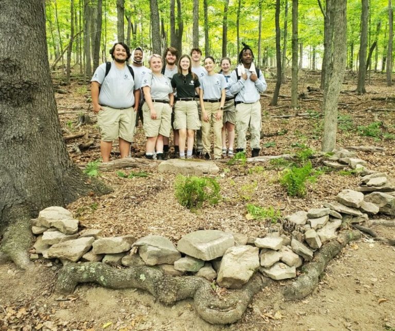 A group of Americorp members in the woods posing for a photo