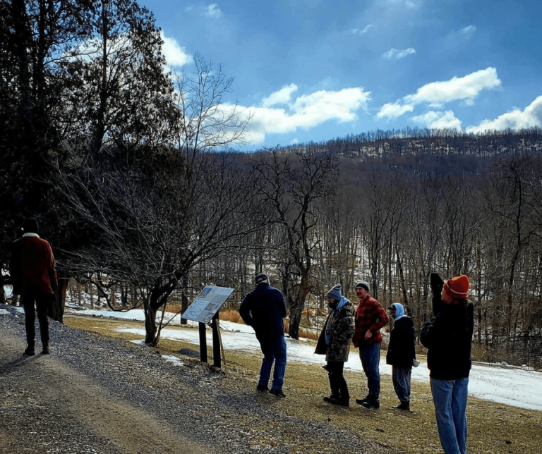 Group of people outdoors on a gravel road with a view of the mountains