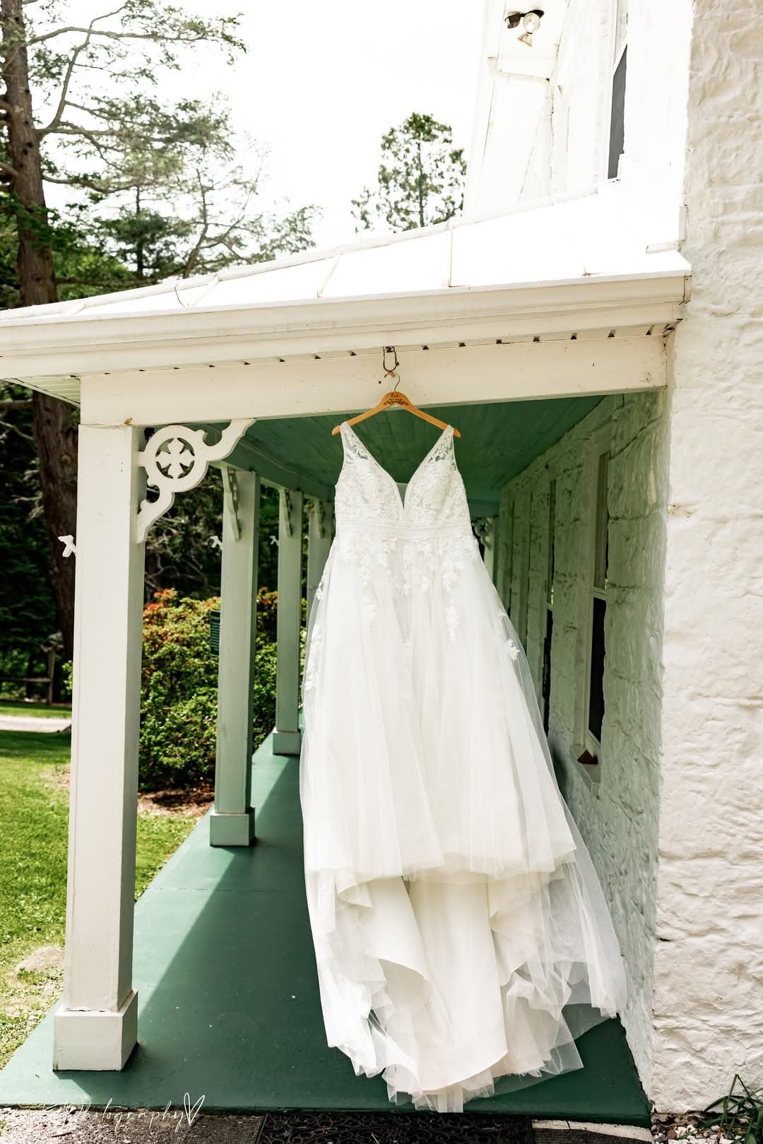 White wedding dress hanging from a porch beam of the historic house.